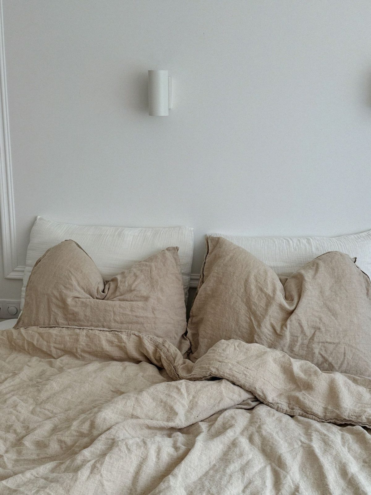 A bed made up in washed oat linen